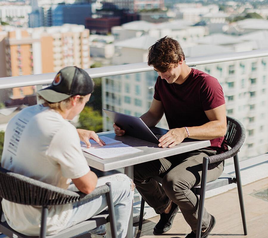 Two PBA students study on a rooftop.